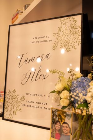 Wedding welcome sign with elegant calligraphy and floral decorations displayed at reception.