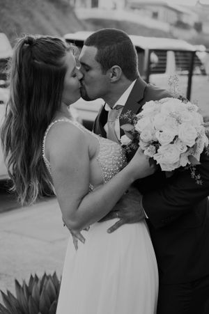 Black and white wedding photos showing tender moments between bride and groom with floral bouquet.