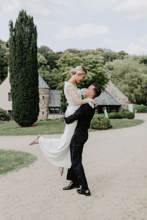 mariée dans les bras de son, mariés devant  Orangerie de Kerstrad