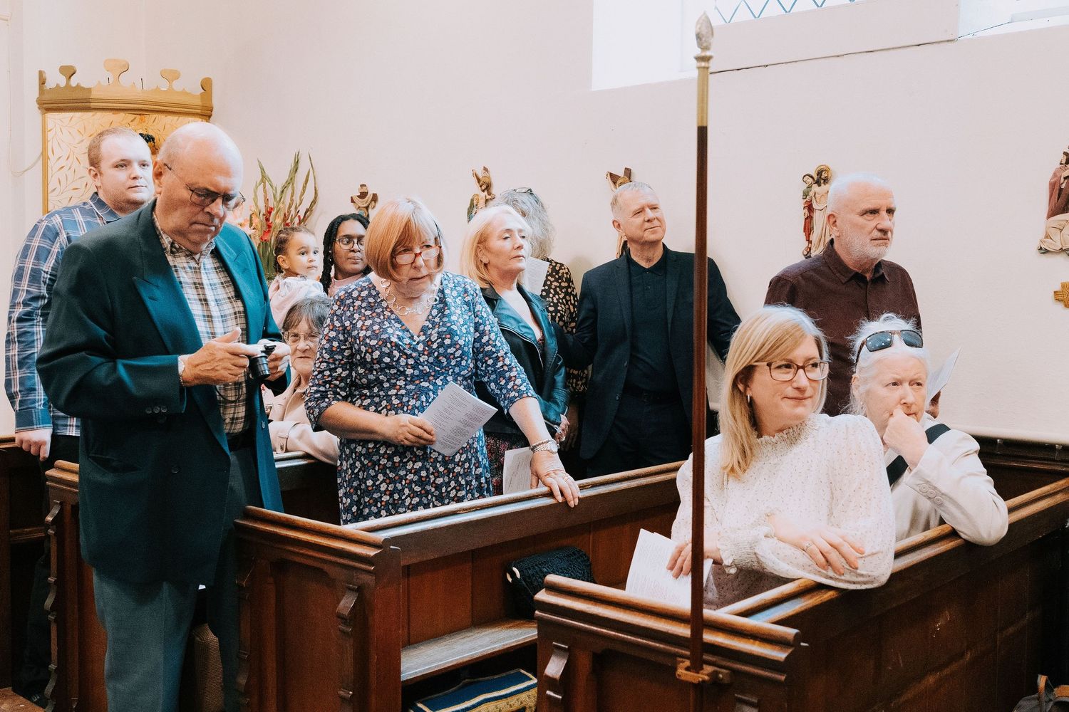 Church congregation gathered for a service with wooden pews and traditional architecture.