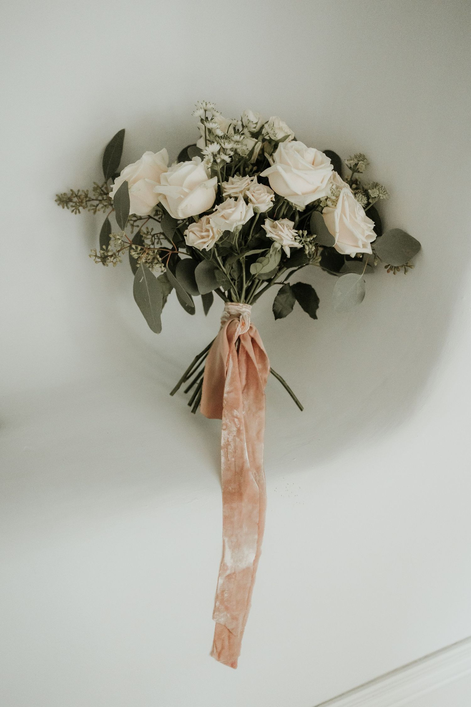 White rose wedding bouquet with eucalyptus and peach ribbon at Aswarby rectory.