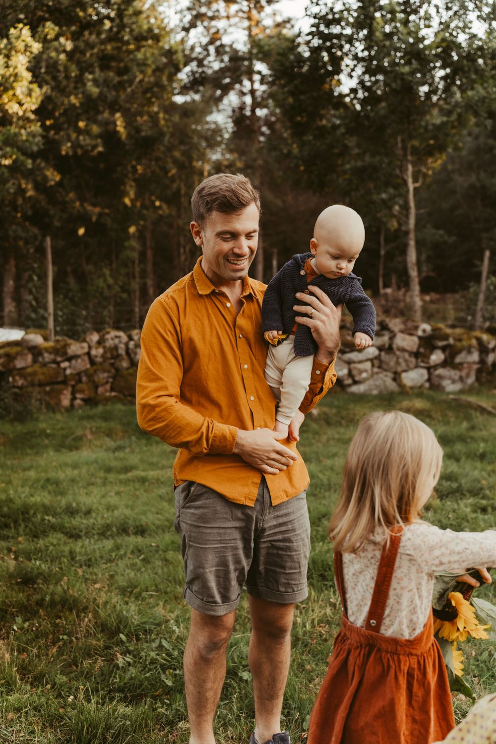 A family enjoys quality time together outdoors during golden hour in a rustic country setting.