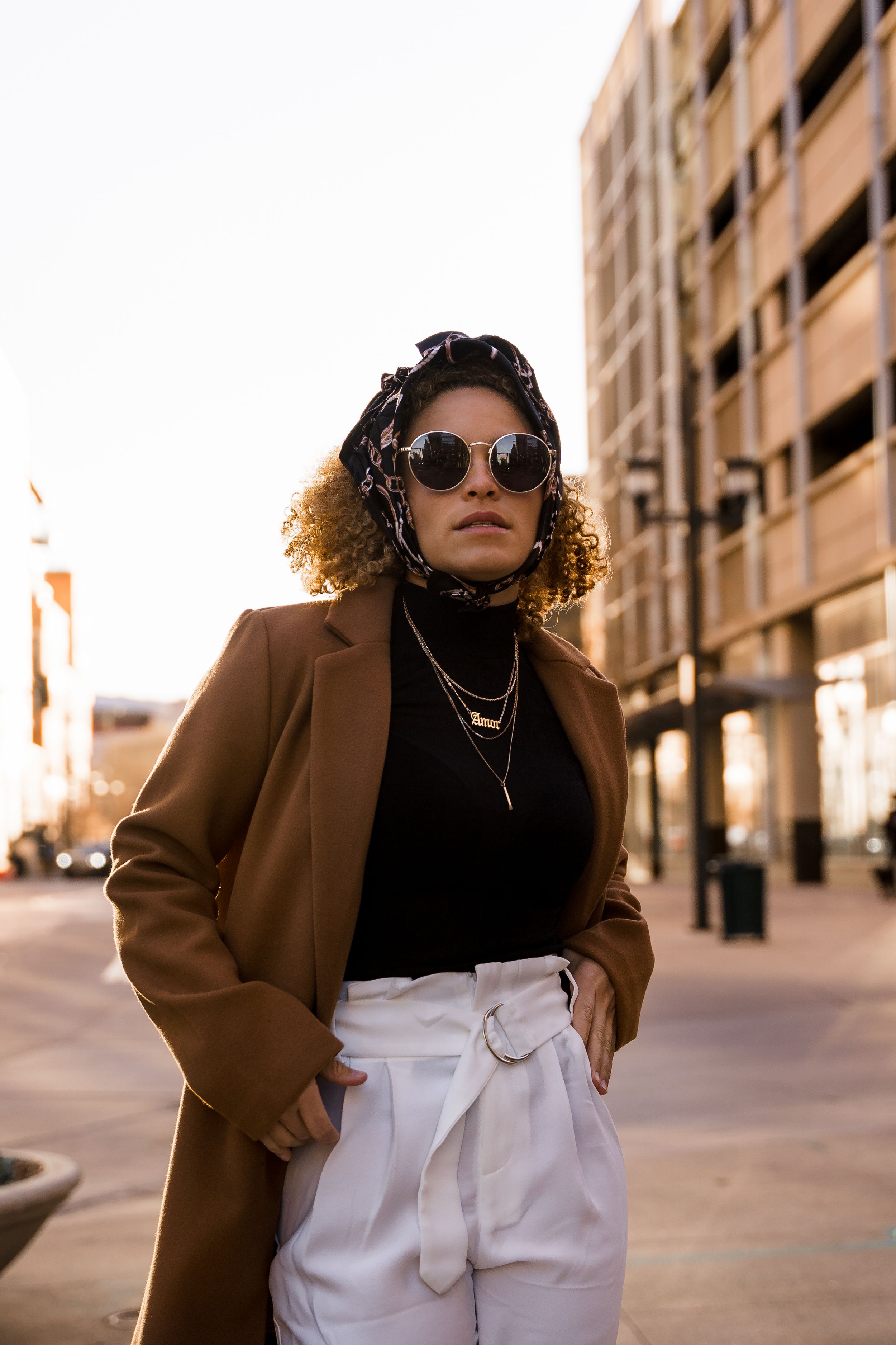 Street style photography with brown coat and sunglasses in urban setting.
