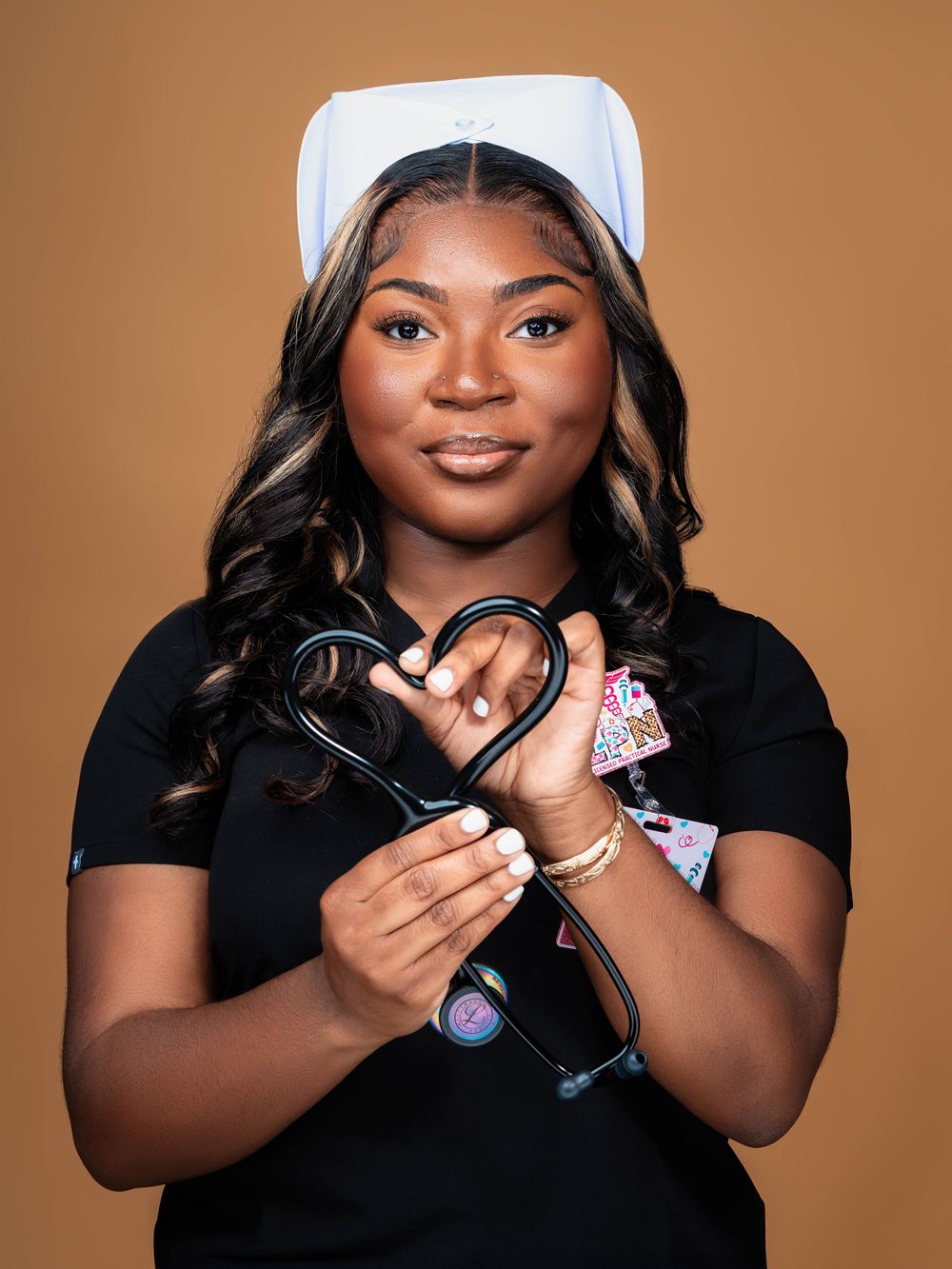 Healthcare worker in white cap holds stethoscope against brown background.