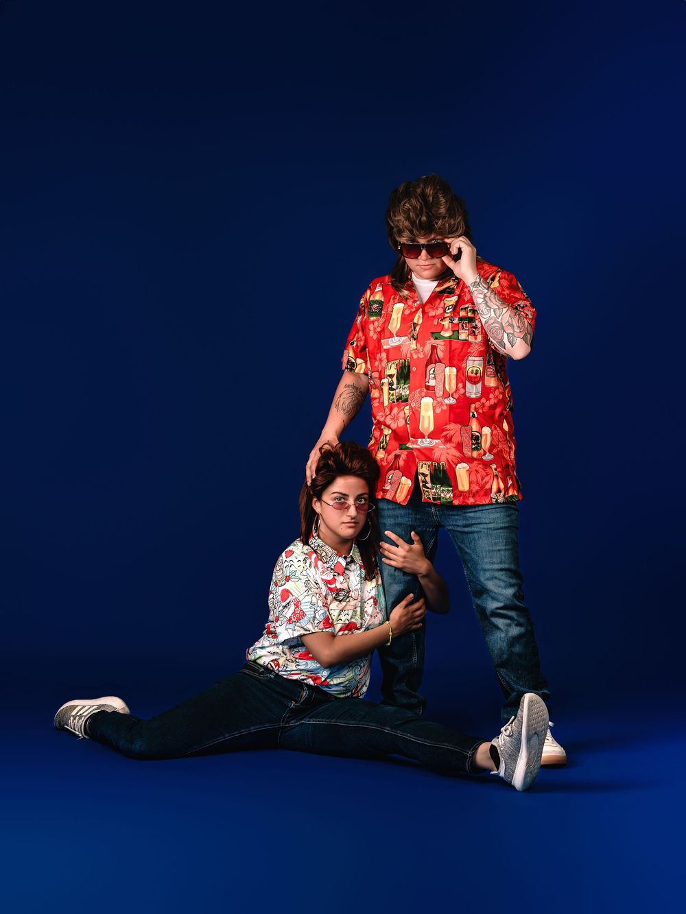 Person in a festive red Hawaiian shirt lounges and stretches on a dark blue backdrop in multiple dynamic poses.