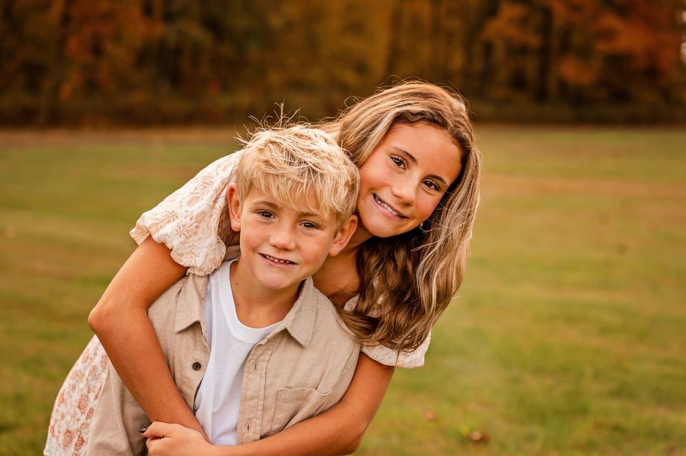 Parent and child enjoying a tender moment together outdoors in a sunny autumn field.