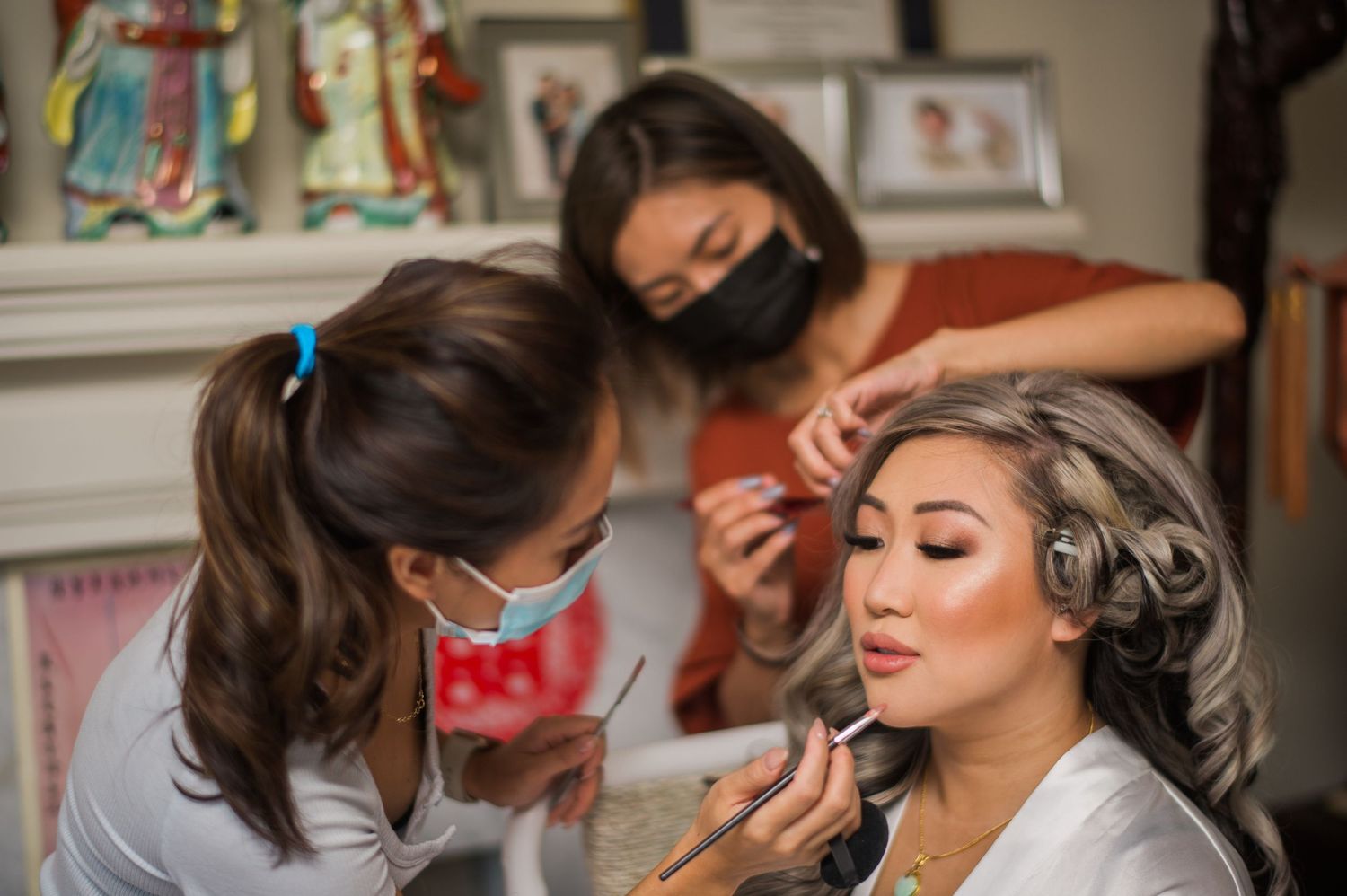 Professional makeup artists working on client's beauty preparation in studio setting.