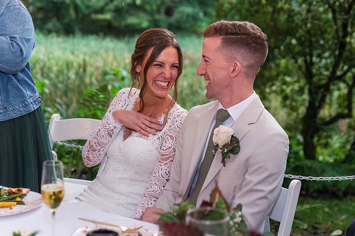 Bride and groom smiling during wedding reception toast