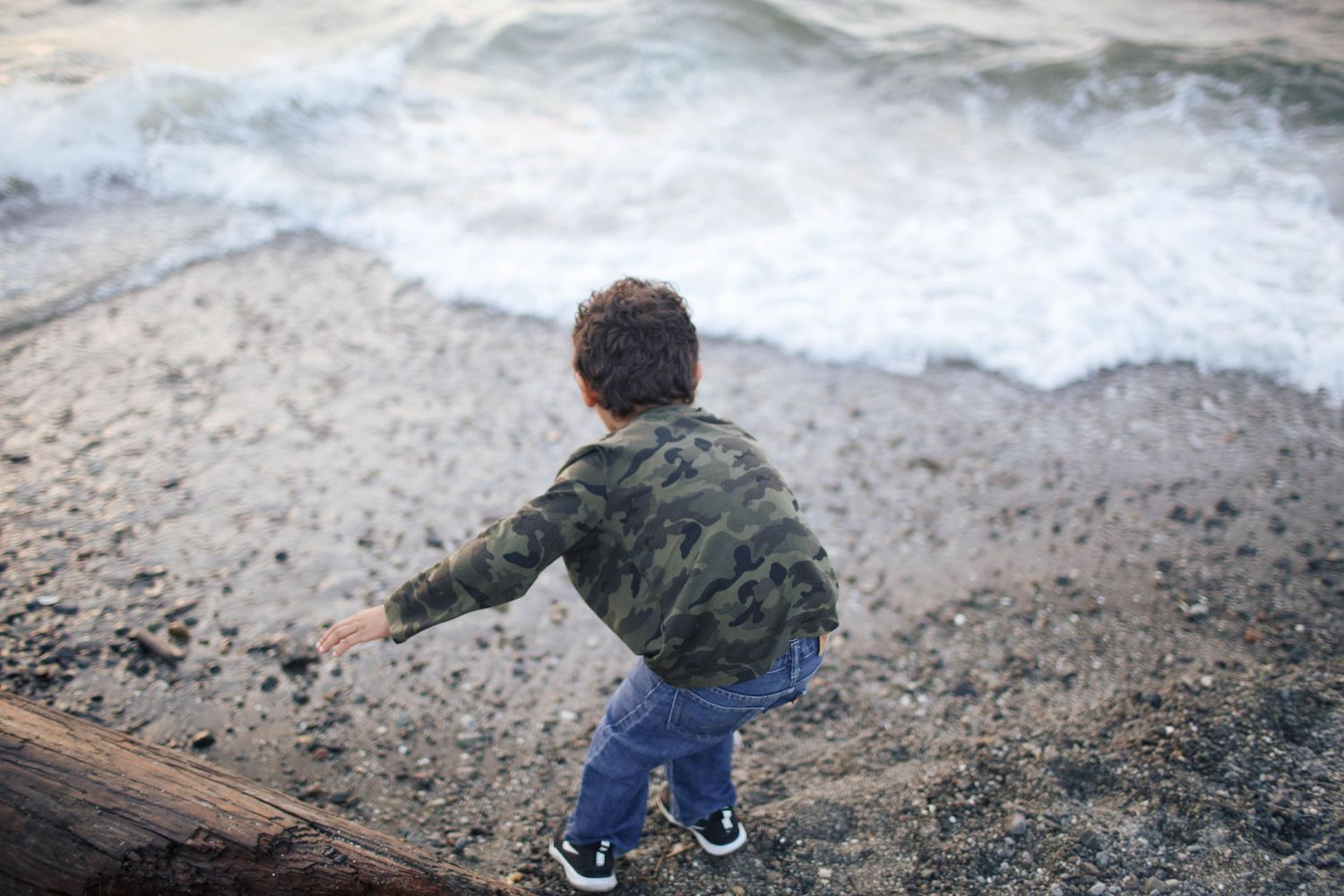 Everett Candid family photography: A young boy plays near the shore at the Mukilteo Lighthouse park in Mukilteo WA