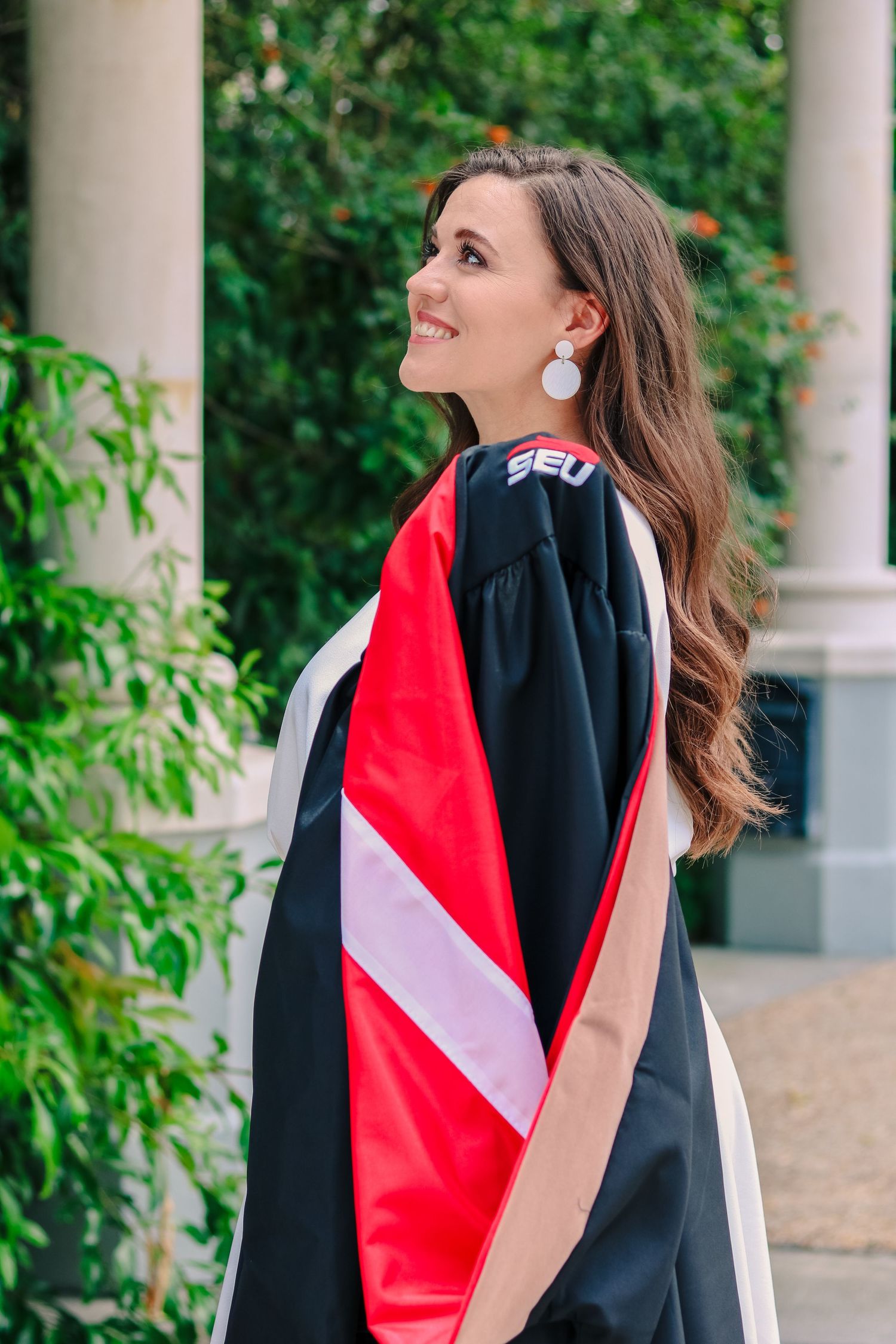 girl holding graduation gown for a photo