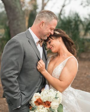 Romantic wedding portrait with bouquet featuring white and peach roses.