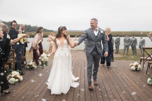 Wedding celebration on a wooden deck overlooking a scenic outdoor landscape.
