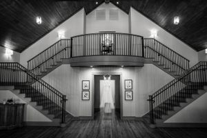 Interior venue space with dramatic lighting and symmetrical staircases leading to a second floor.