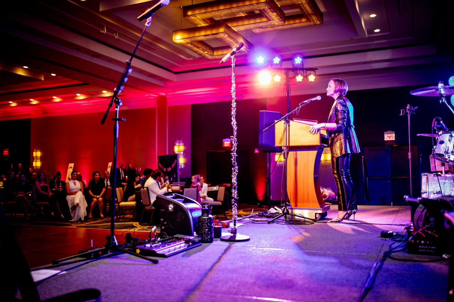 Dramatic concert performance with colorful stage lighting and musicians performing on stage.