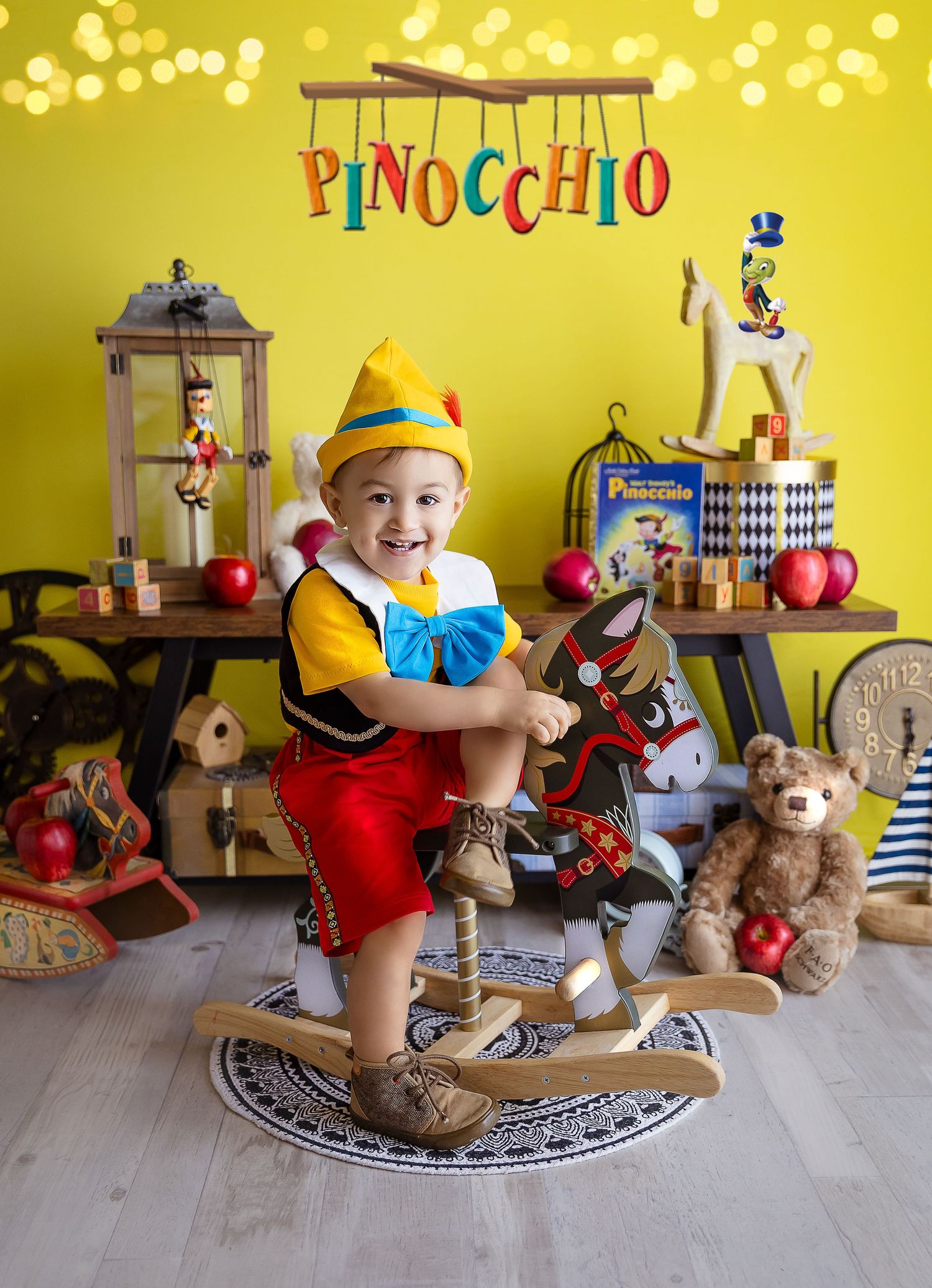 sesion fotografica bebe vestido de Pinocho de 2 anos montado en un caballito de madera