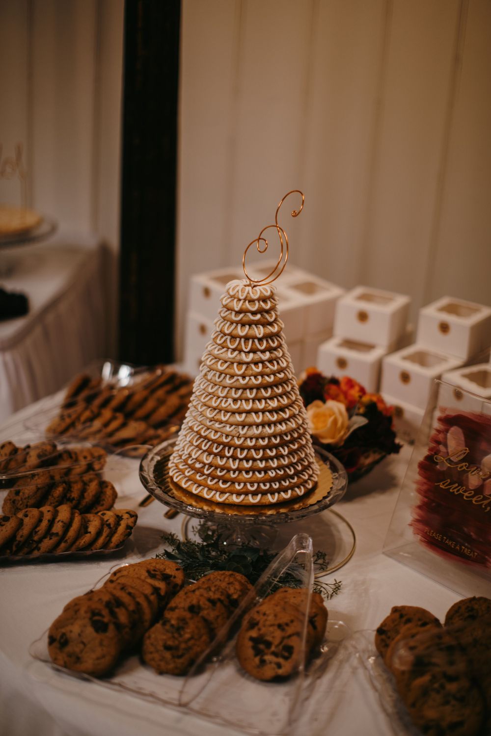 Elegant wedding dessert table featuring a traditional Norwegian kransekake tower surrounded by assorted cookies.