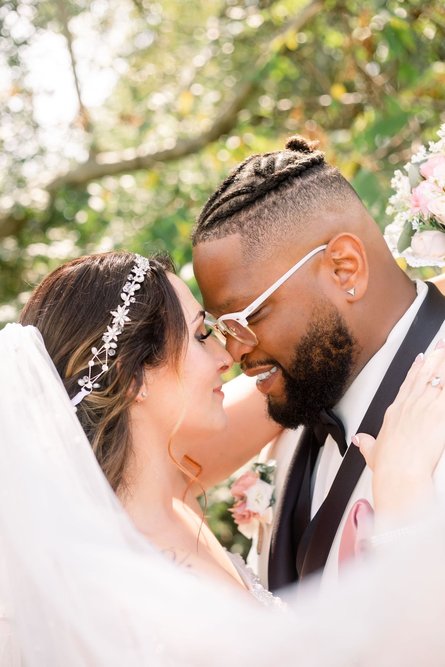 Intimate wedding portrait captured in a lush garden setting with natural lighting.
