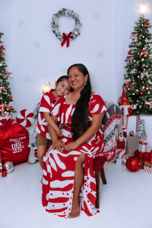 Joyful holiday portraits in red and white peppermint-themed outfits with Christmas decorations.