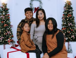 Family members in coordinating outfits share candid moments during Christmas photo session.