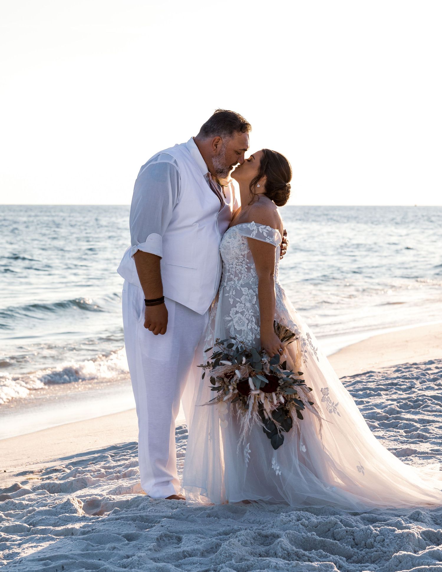 A romantic beach wedding moment with turquoise ocean waters in background.