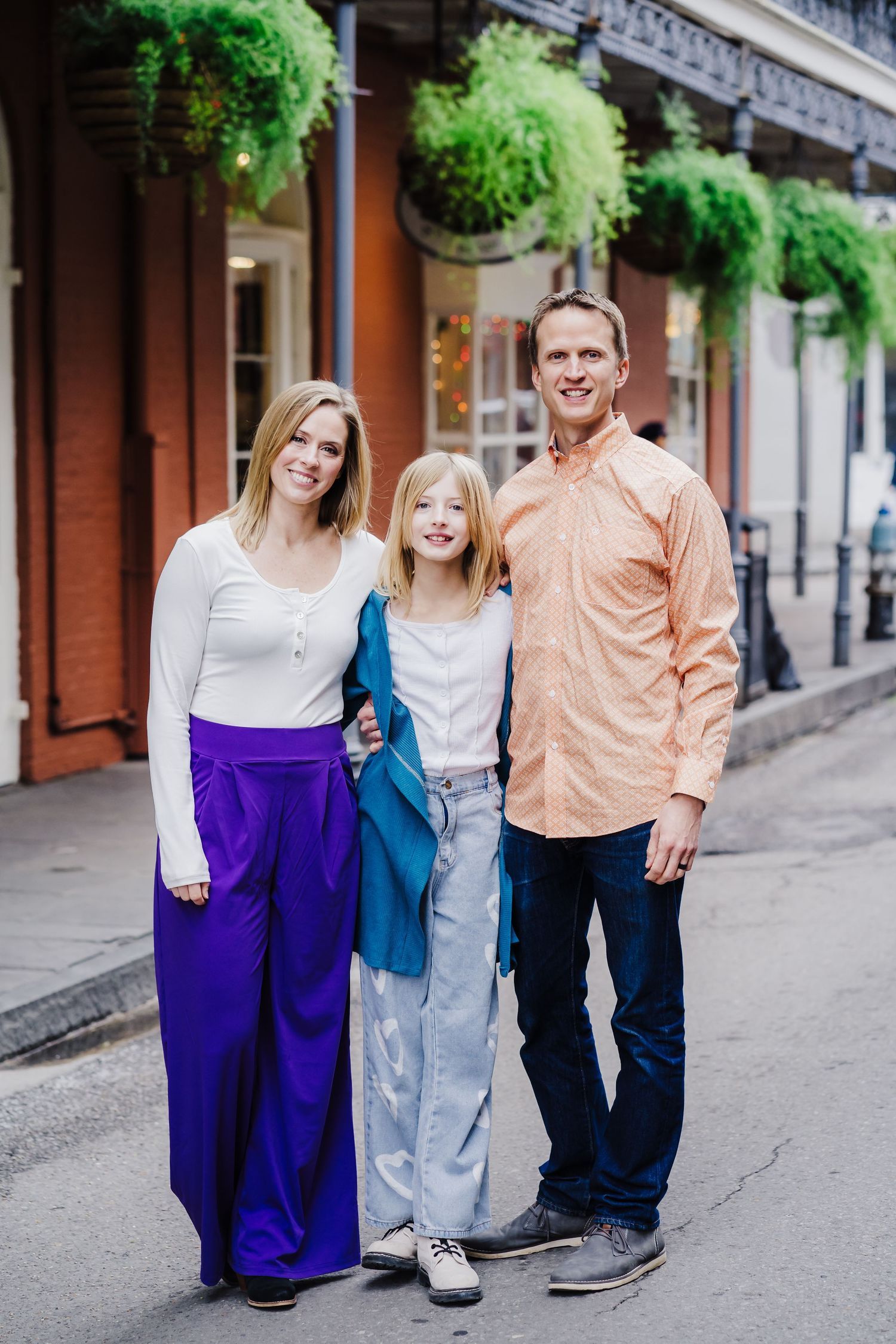A family of three poses together on Royal Street in New Orleans.