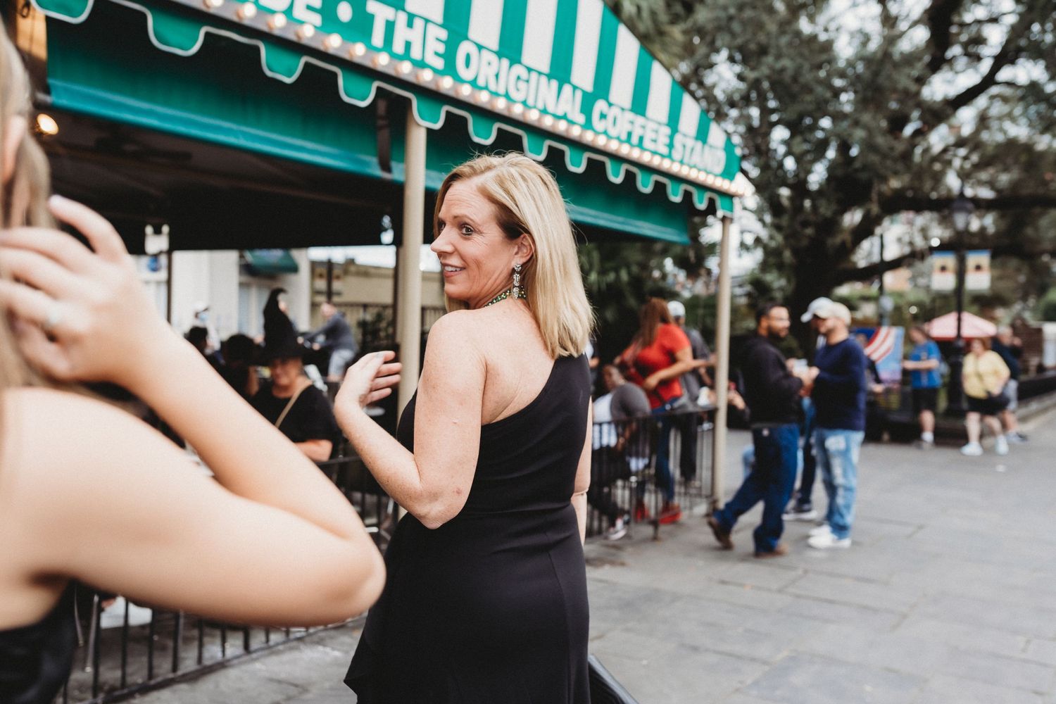 A woman looks behind her as she walks towards Cafe du Monde.