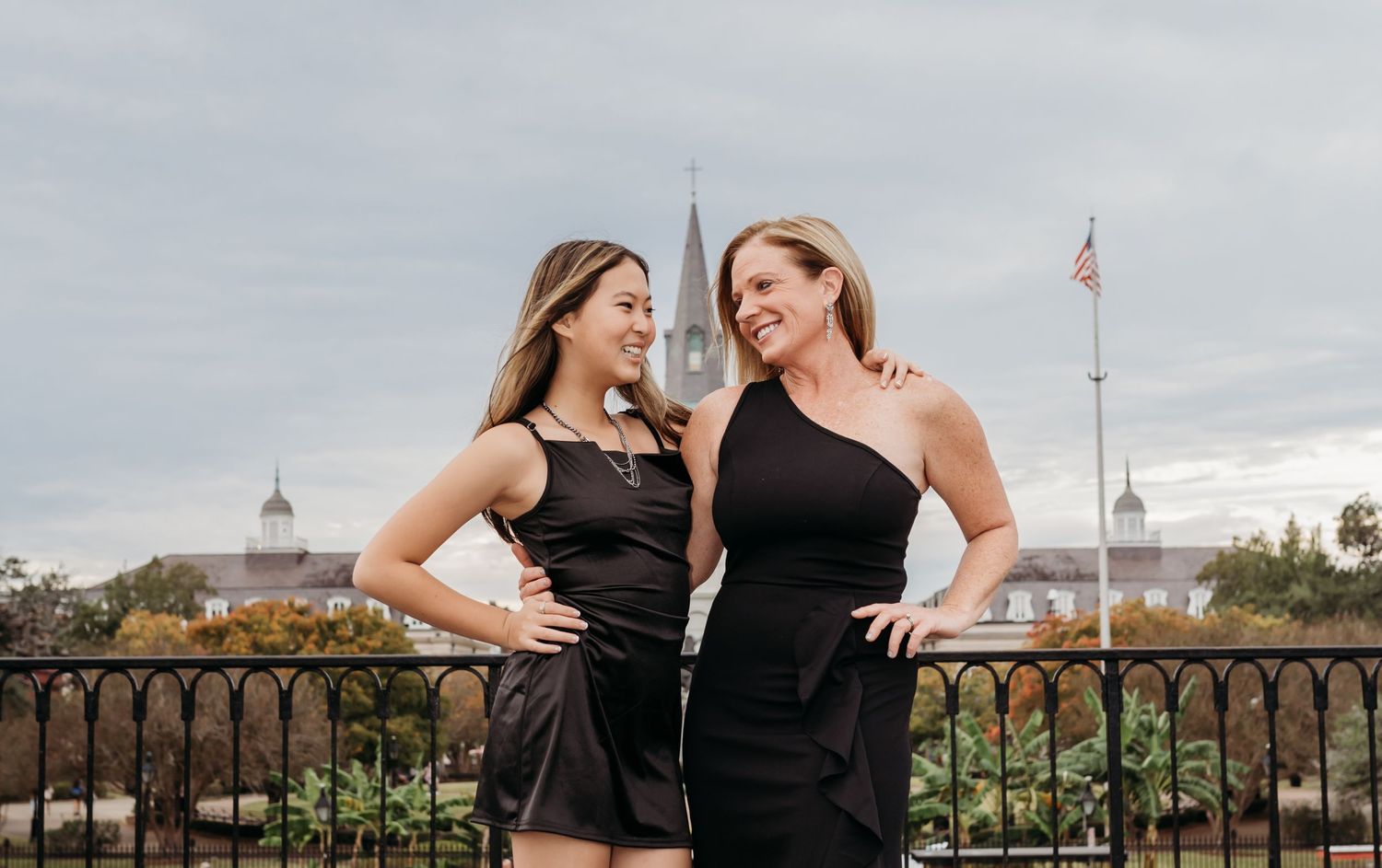 Mother and daughter share a hug at Washington Artillery with the St. Louis Cathedral behind them.