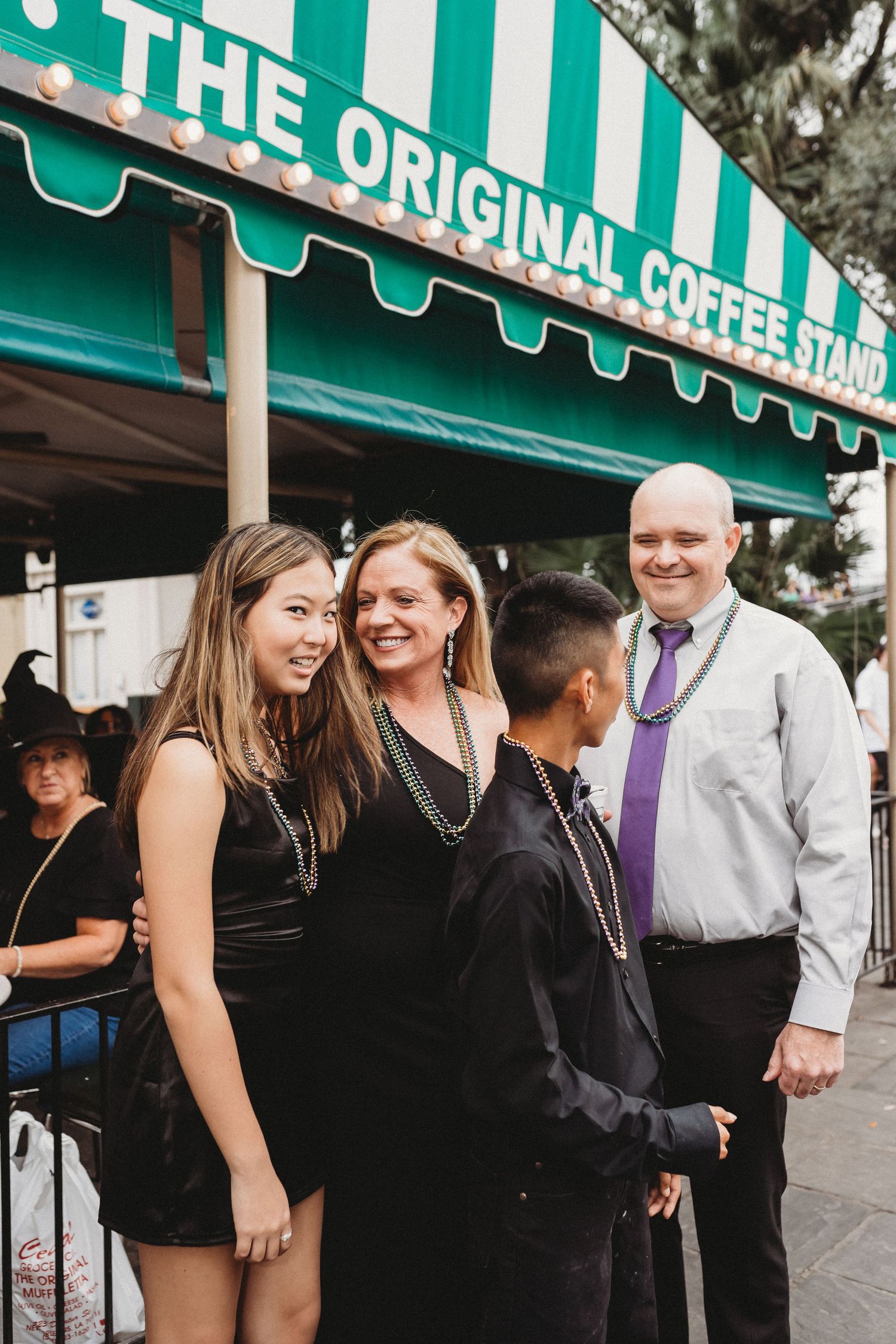 A family of four laughs together on Decatur Street in New Orleans.