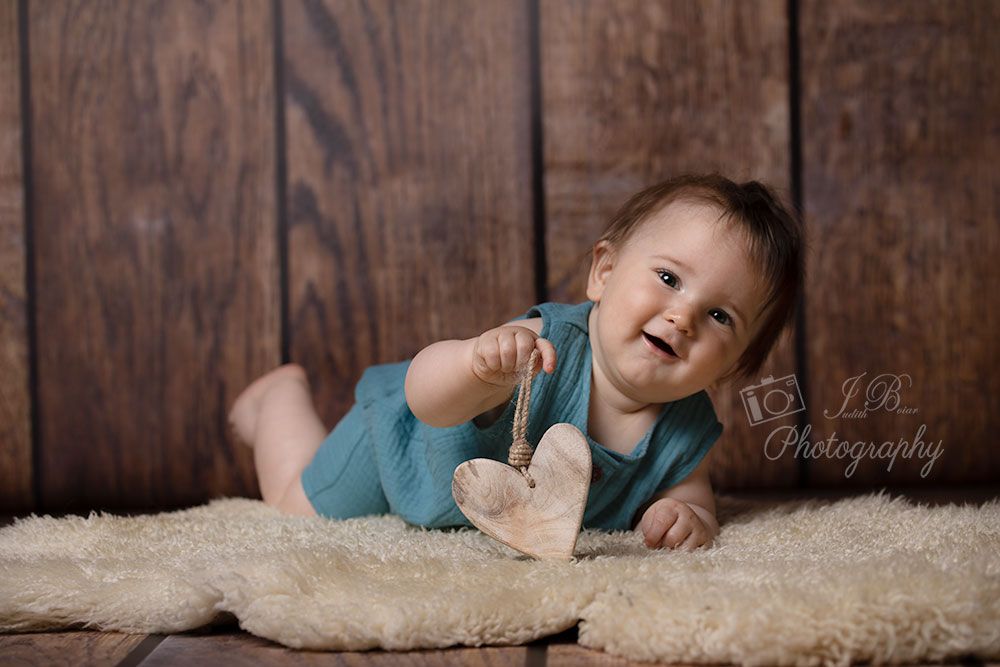 lachendes Baby hält ein Herz in der Hand. Babyfotos in Gelsenkirchen und Umgebung. Ruhrgebiet. Fotograf Gelsenkirchen