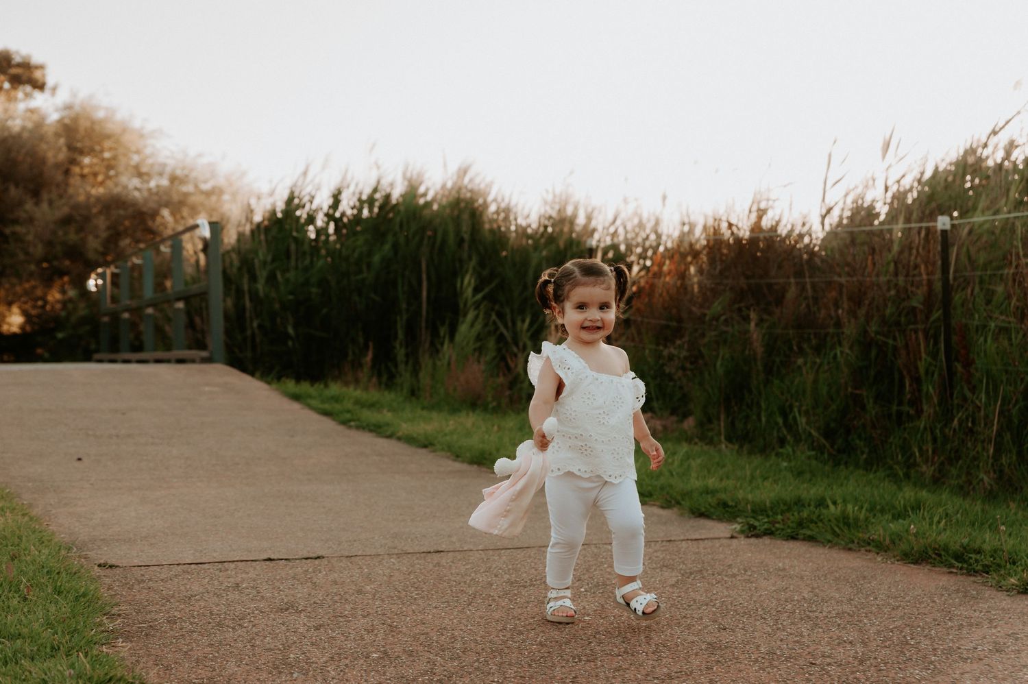 A child runs along a path through tall grass during sunset.
Altona Family Photographer Melbourne