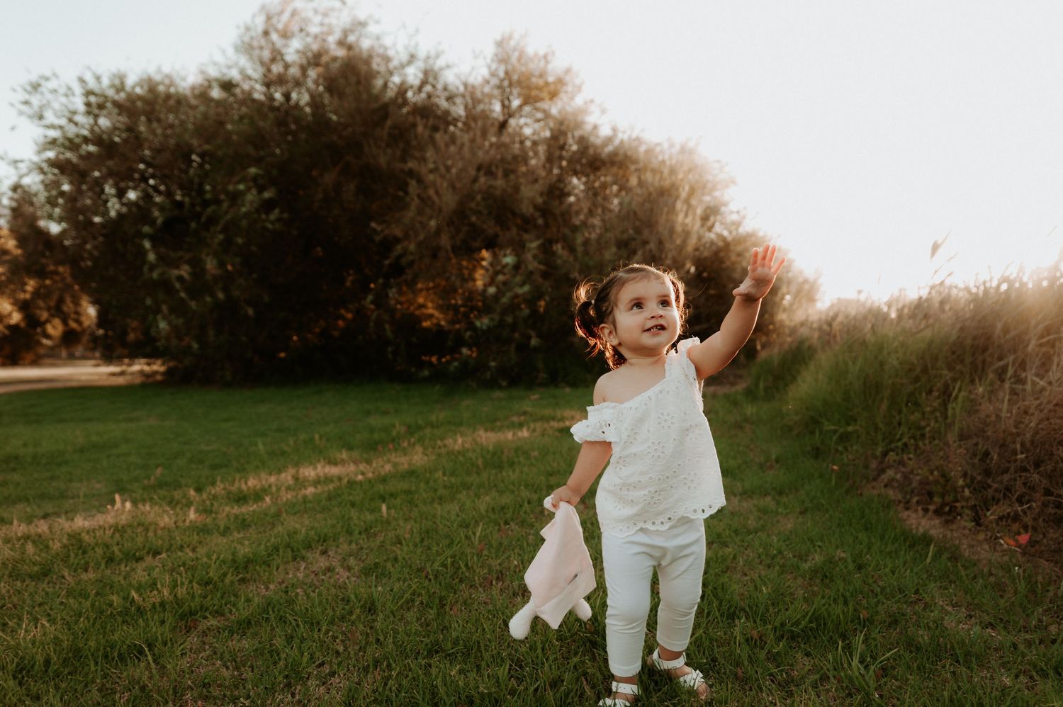 A small child in all white clothing runs joyfully through a grassy field at sunset.
Altona Family Photographer Melbourne