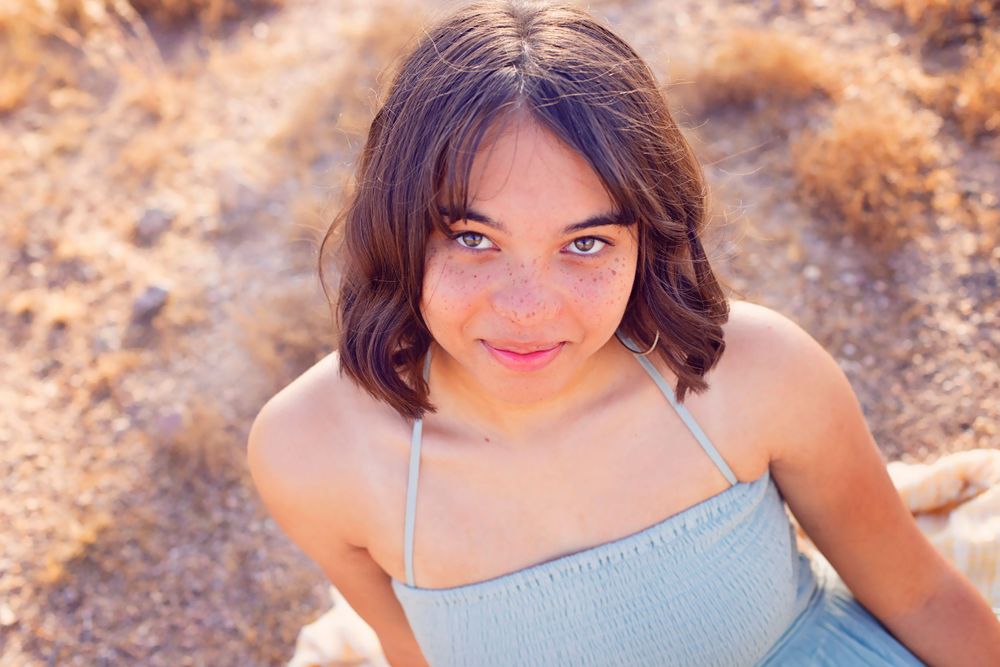 Close-up portrait in desert setting with soft natural lighting.