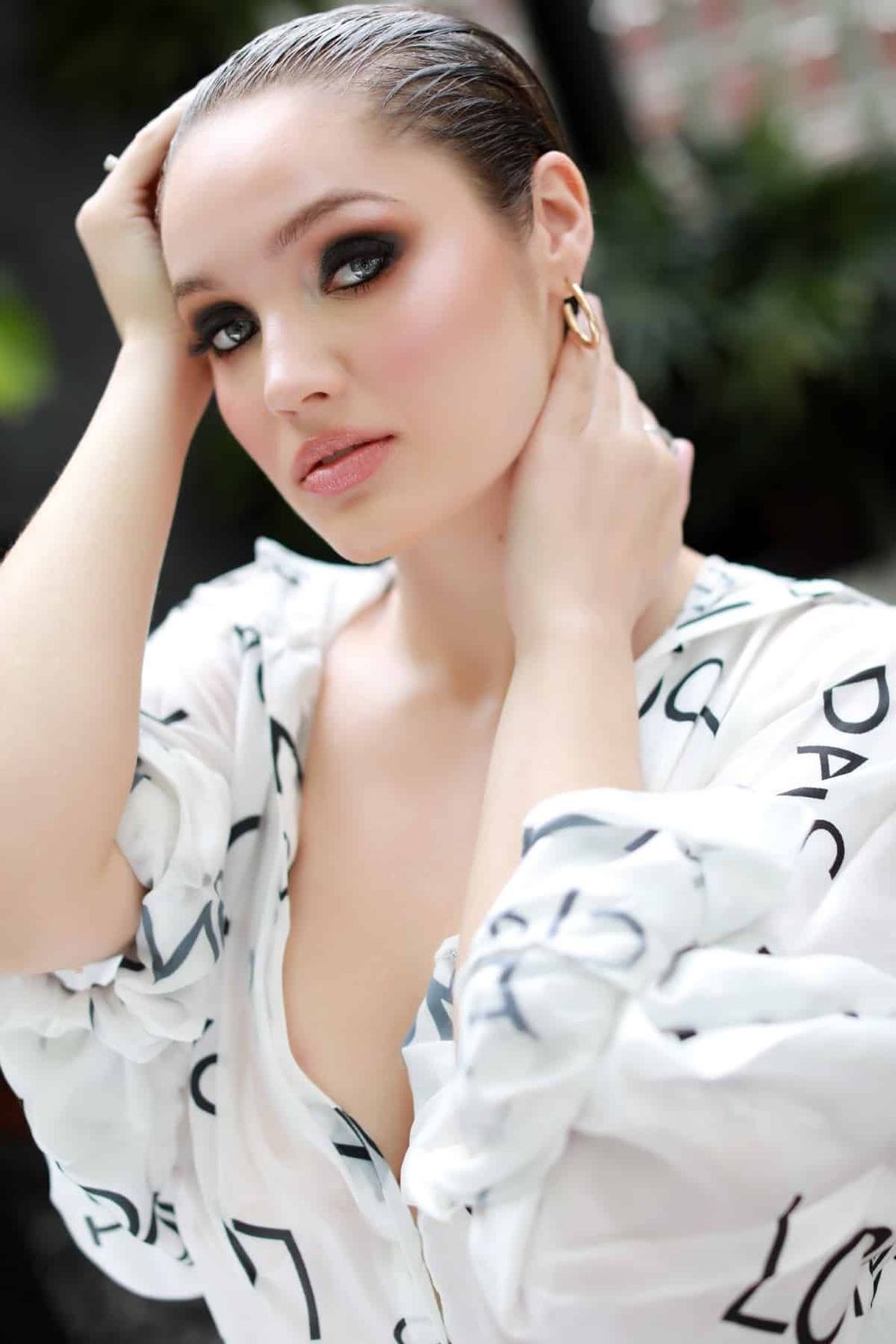 Elegant portrait in white flowing shirt with smokey eye makeup.