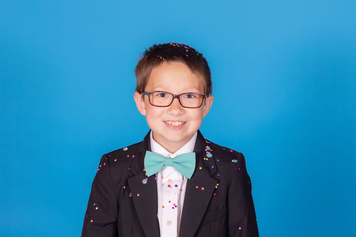 child covered in confetti on savage blue jay backdrop with confetti in studio in clayton new jersey gloucester
