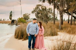 Scenic beach boardwalk with Spanish moss hanging from trees at dusk.