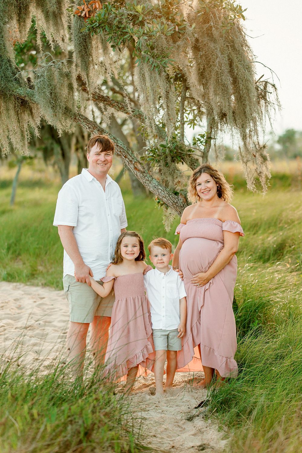 Family portrait session at Goose Creek State Park Waterfront path with Spanish moss hanging from trees in soft evening light.