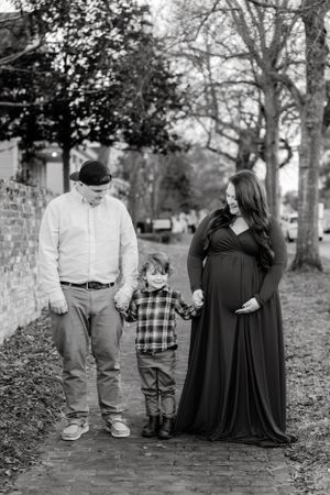 Black and white outdoor family portrait session among autumn trees.