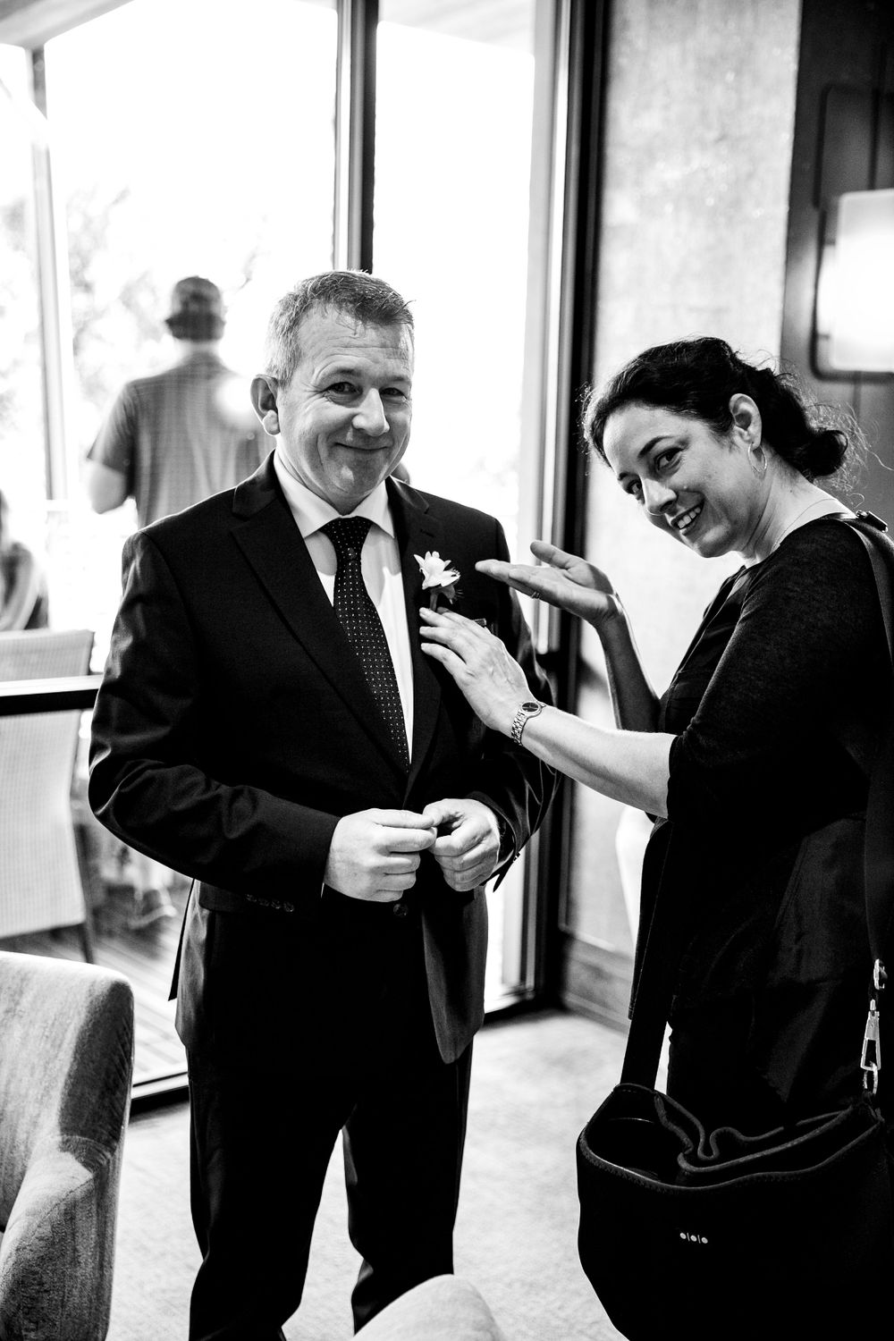 A candid black and white moment during wedding preparations.