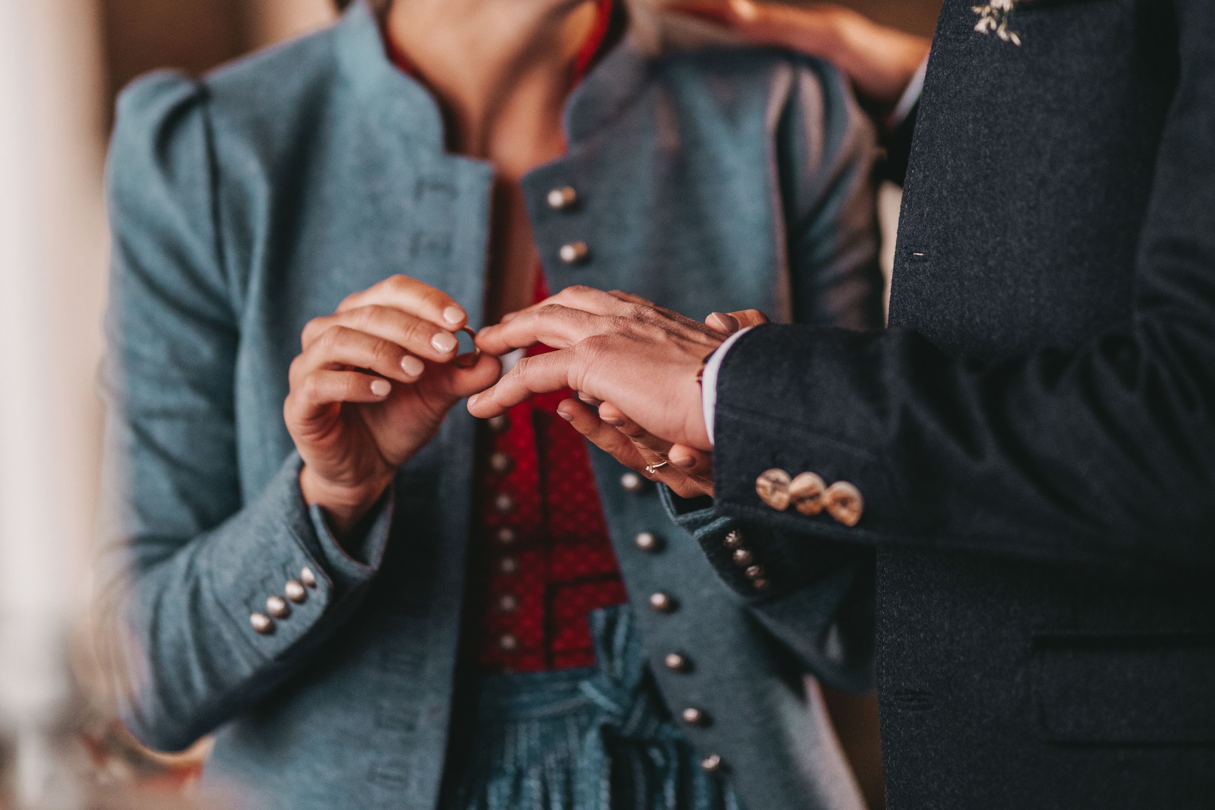 Close-up shot of hands exchanging rings during traditional wedding ceremony.