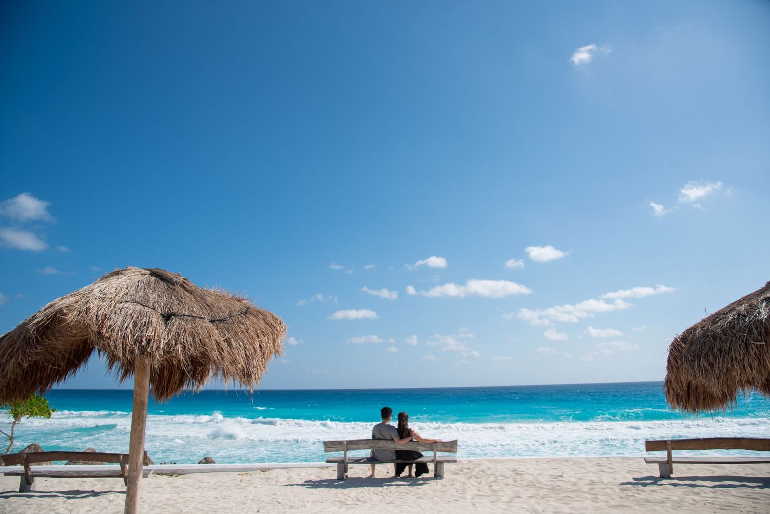 Eric and his wife sharing a loving moment by the turquoise sea in Cancun