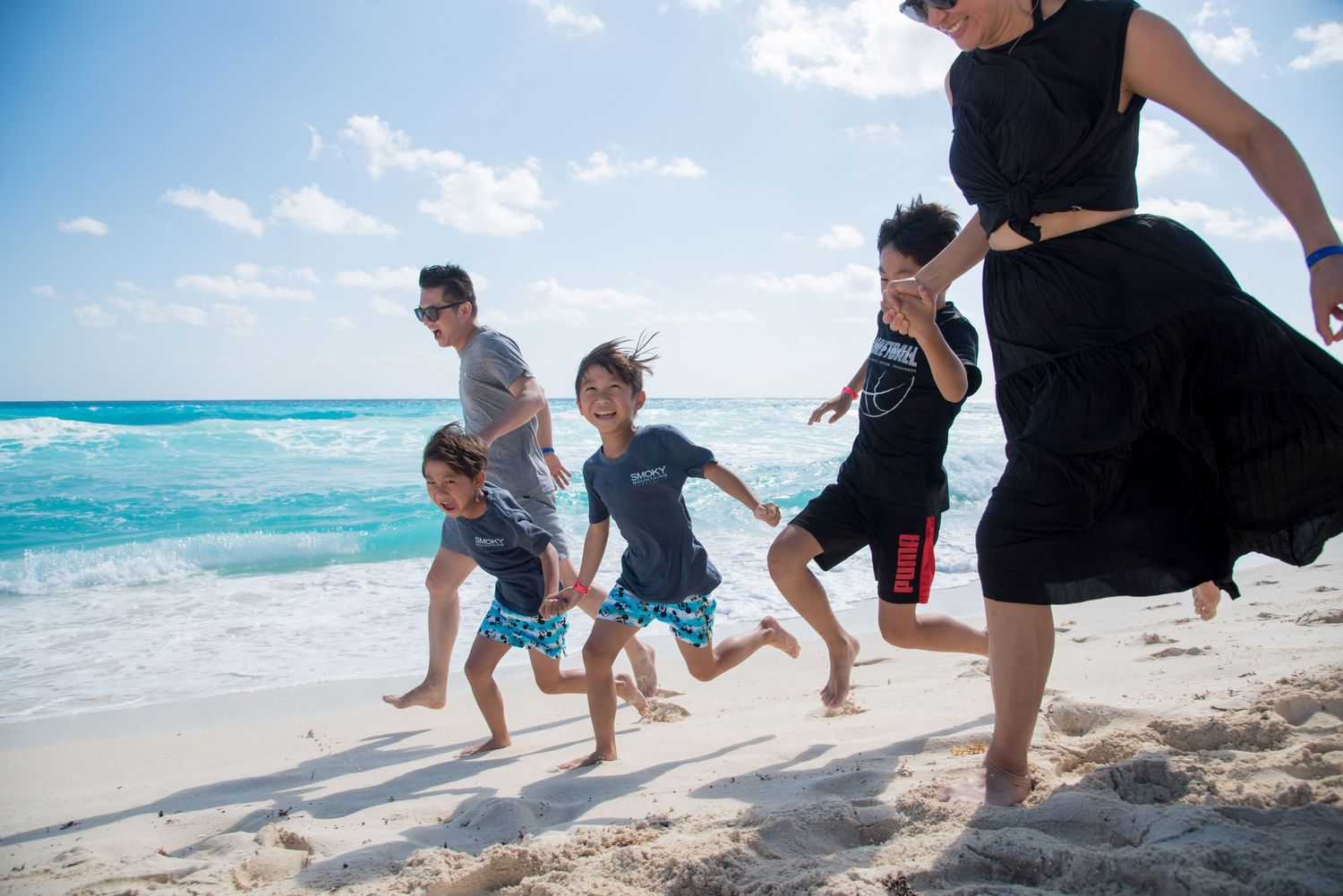 Family members running and enjoying their time together at Playa Delfines