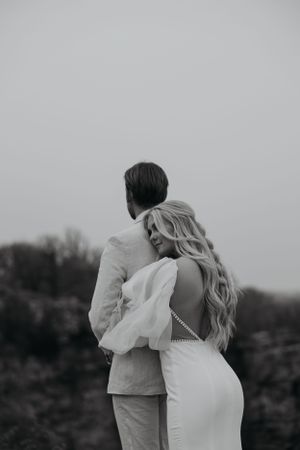 A black and white photo captures a couple from behind in an intimate embrace.