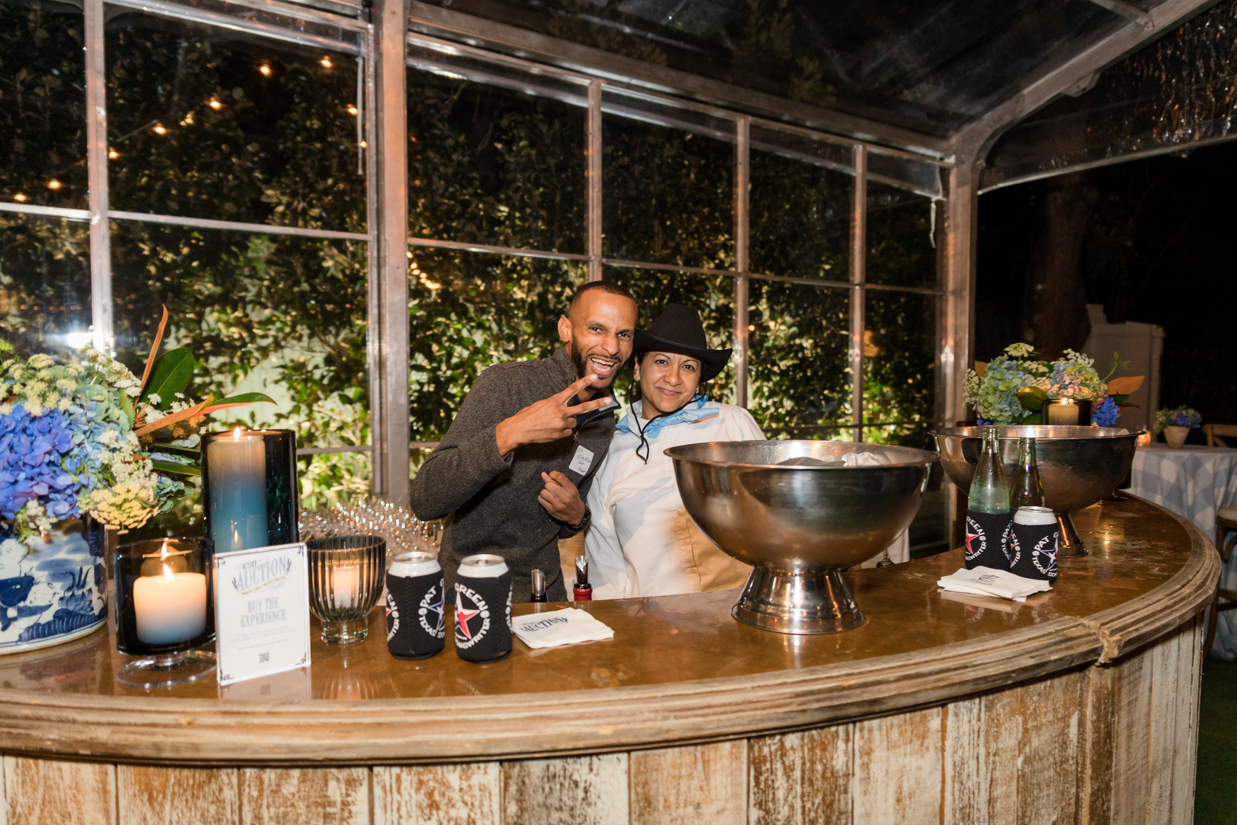 Rustic outdoor bar with curved wooden counter and string lights creating an intimate atmosphere.