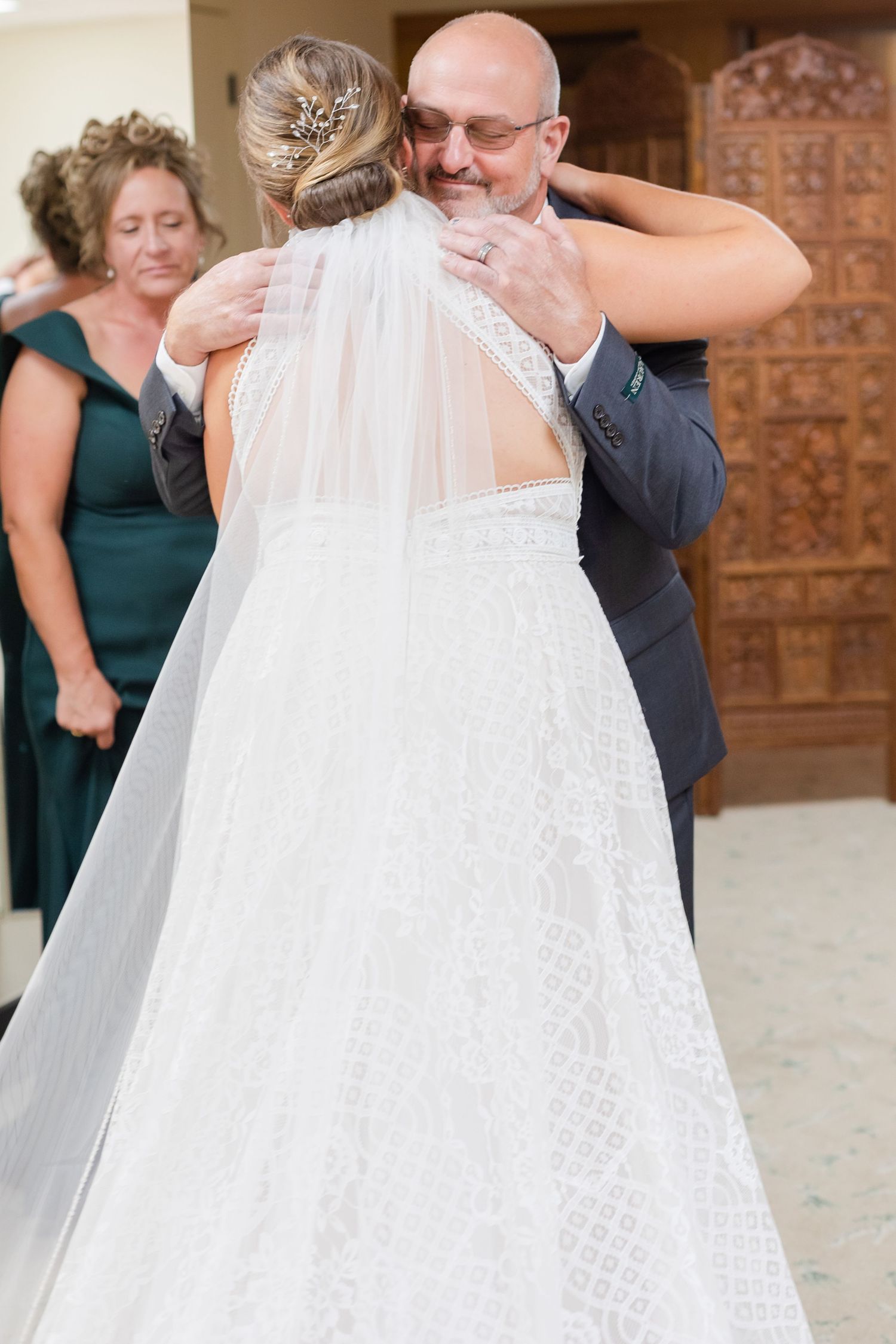 Touching first look moment at wedding with bridesmaids in green dresses watching.