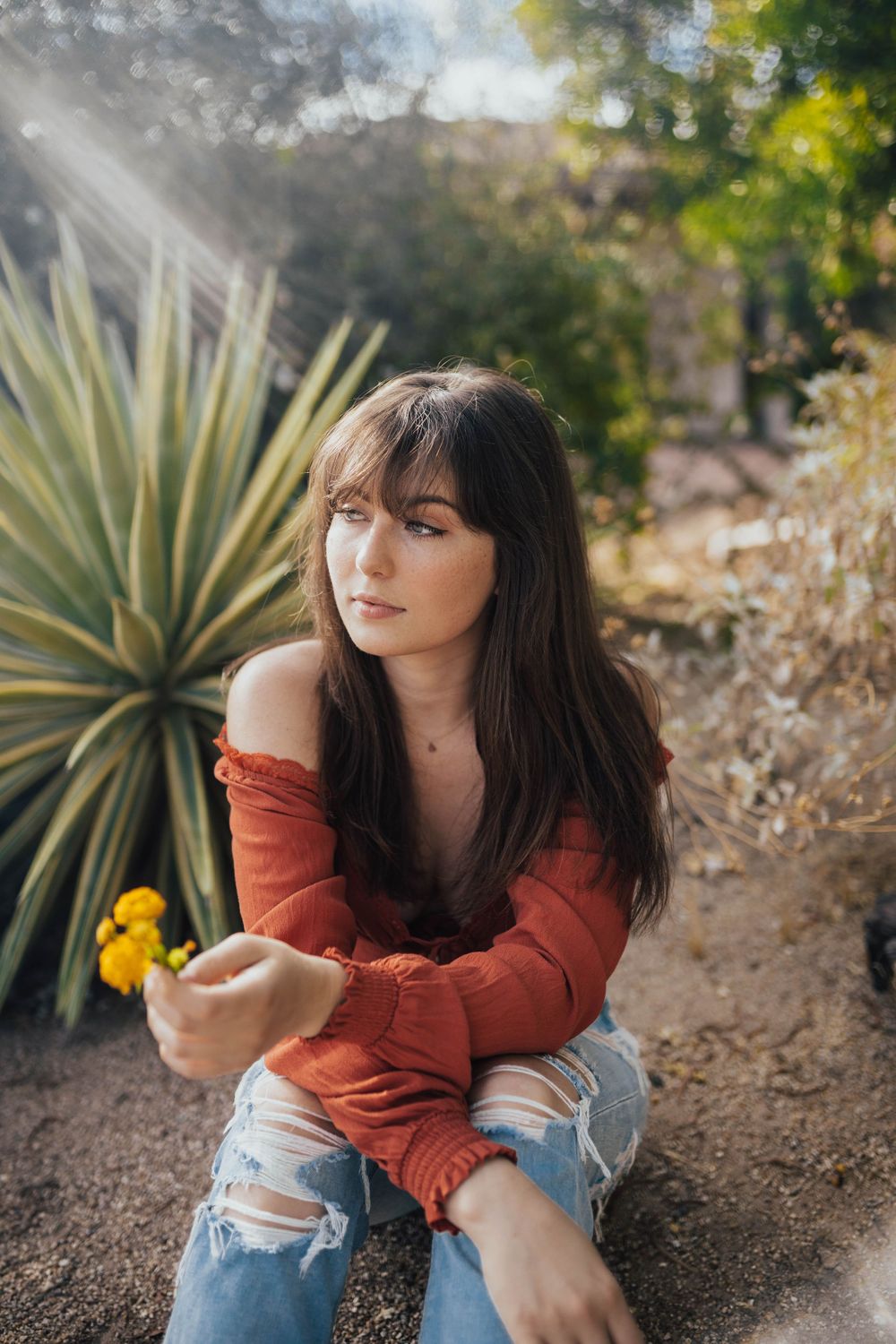 Artistic portrait session in a desert garden with yucca plants and natural lighting.