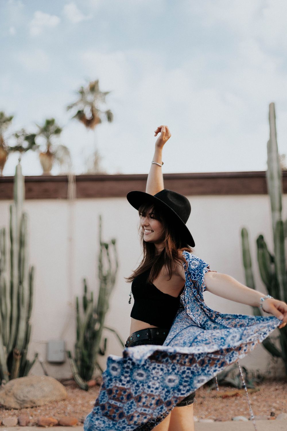 Playful twirling motion shots in a blue dress against desert garden backdrop.