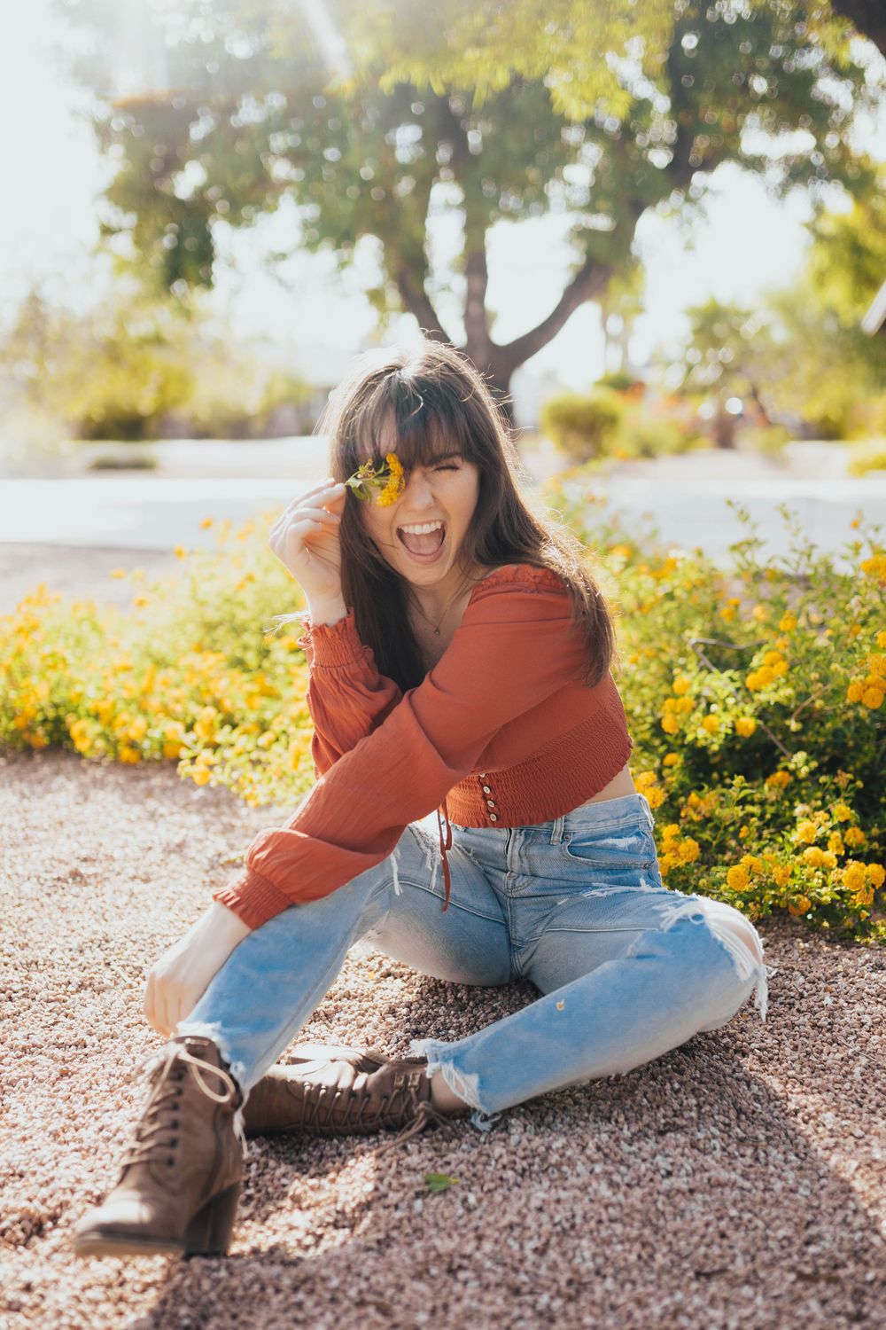 Candid moments captured on gravel ground with yellow flowers and desert plants in the background.
