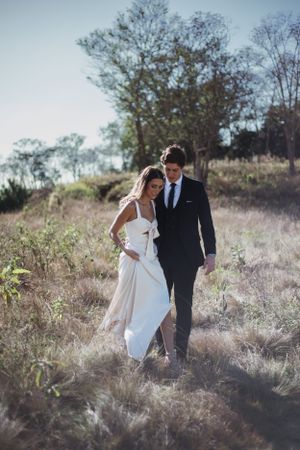 Novios corriendo por el campo en sesión de pareja artísitca