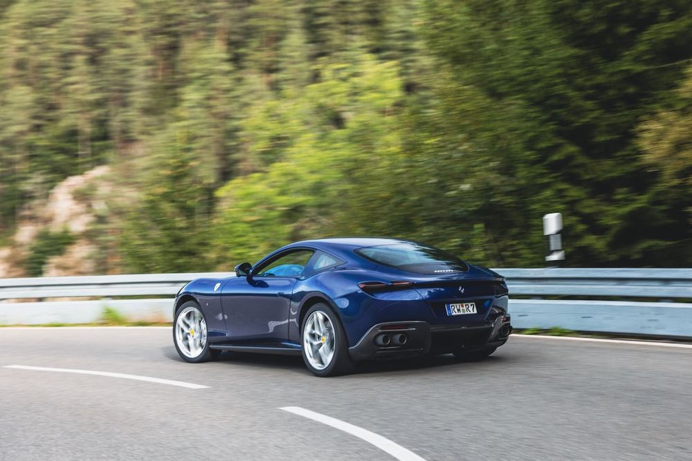 Blauer Ferrari Roma fährt auf einer Landstraße im Schwarzwald