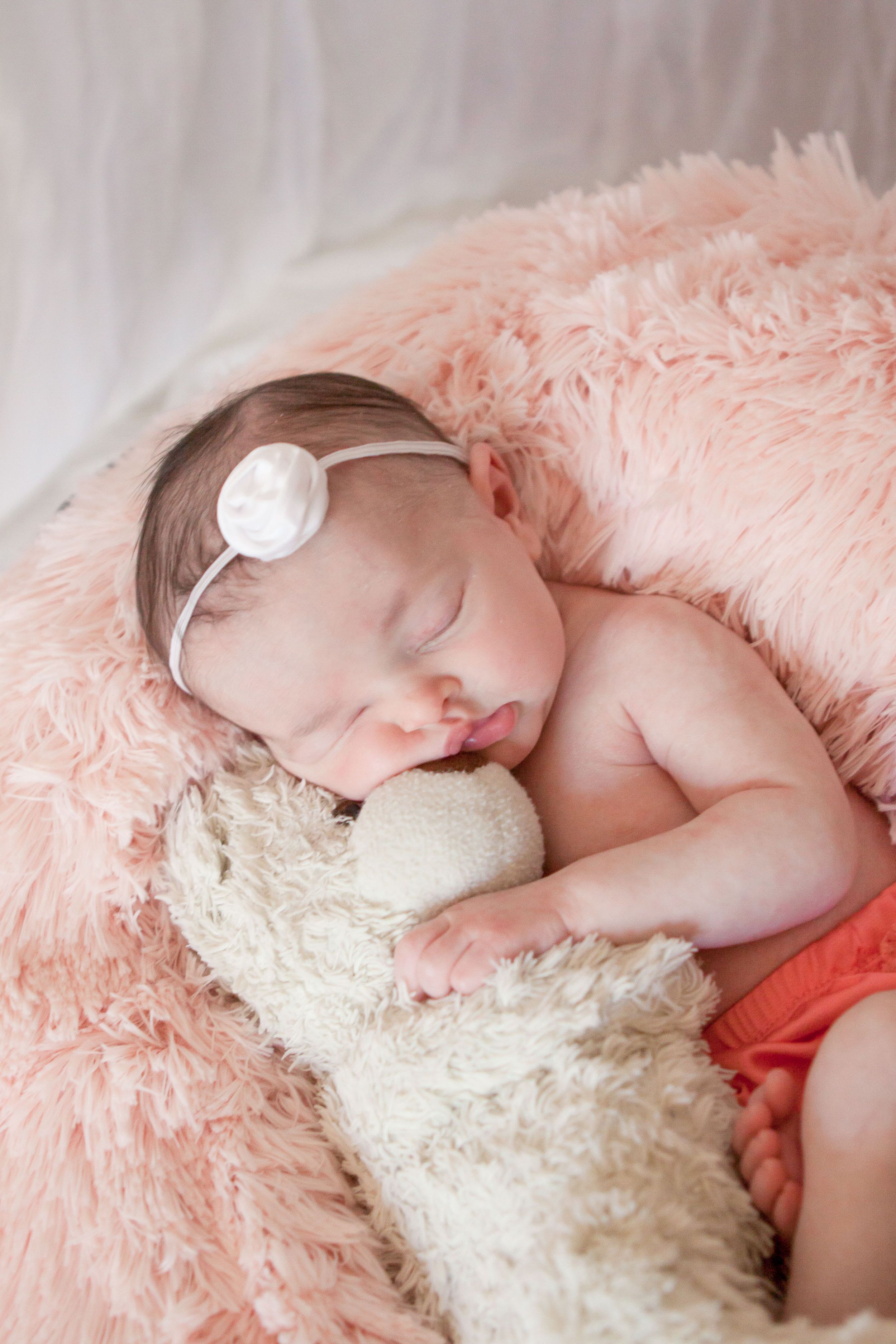 Portrait of a newborn snuggling her teddy bear